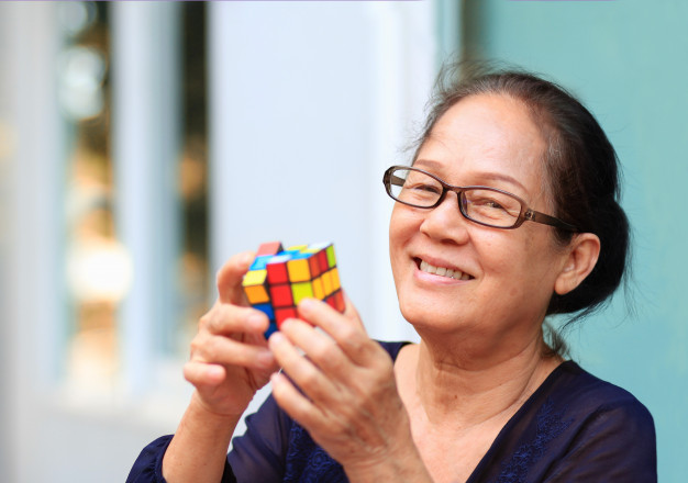 gammel kvinde der løser rubiks cube
